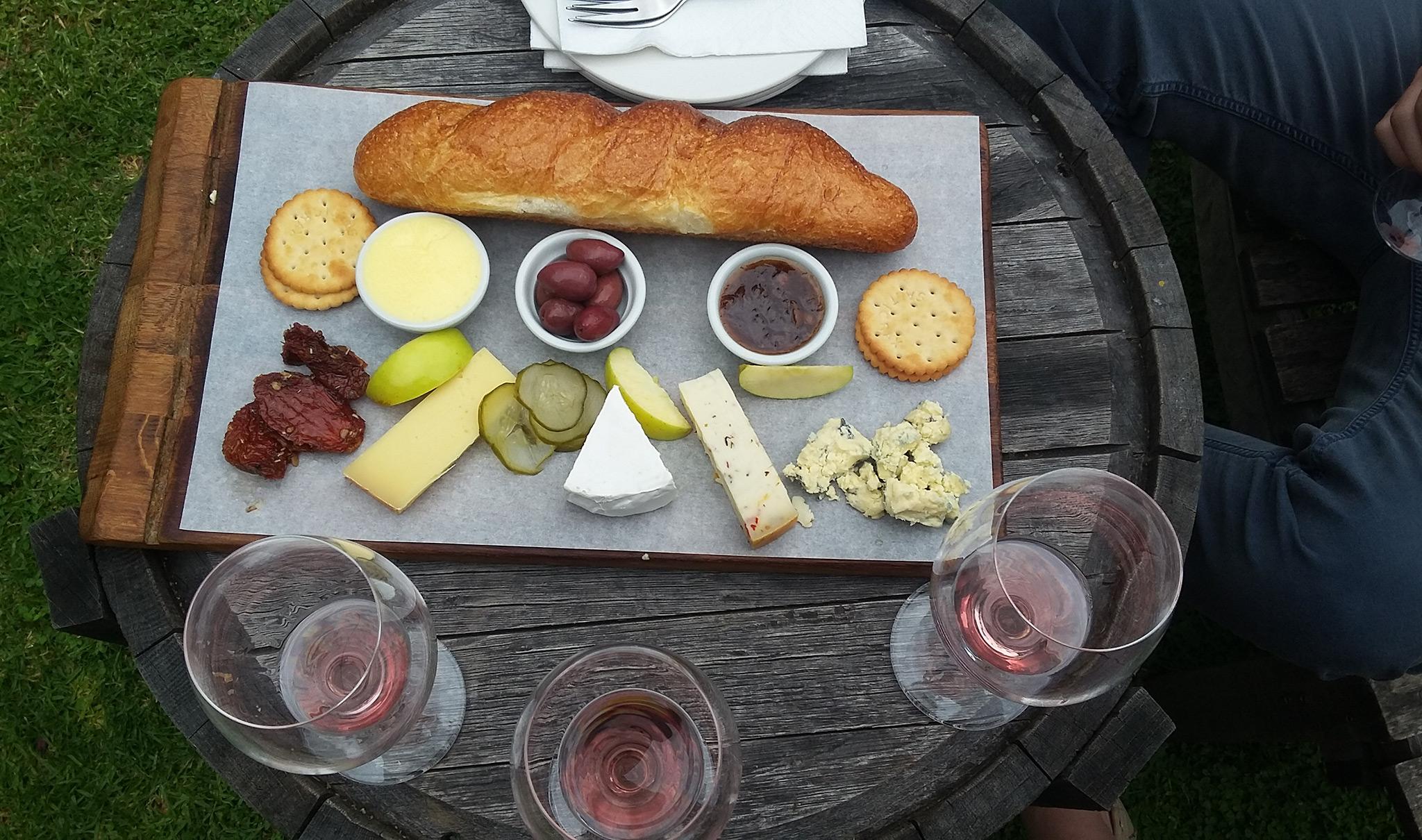 Cheese and charcuterie board paired with glasses of red wine.