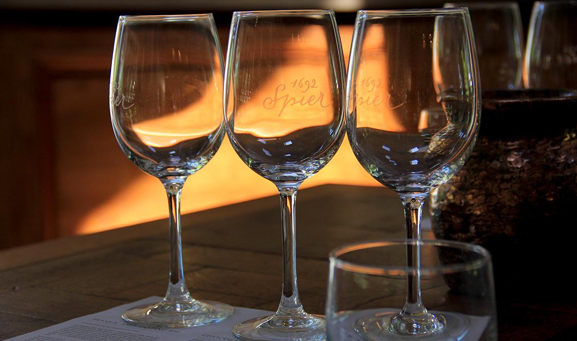 Three empty wine glasses on a wodden table at Spier.