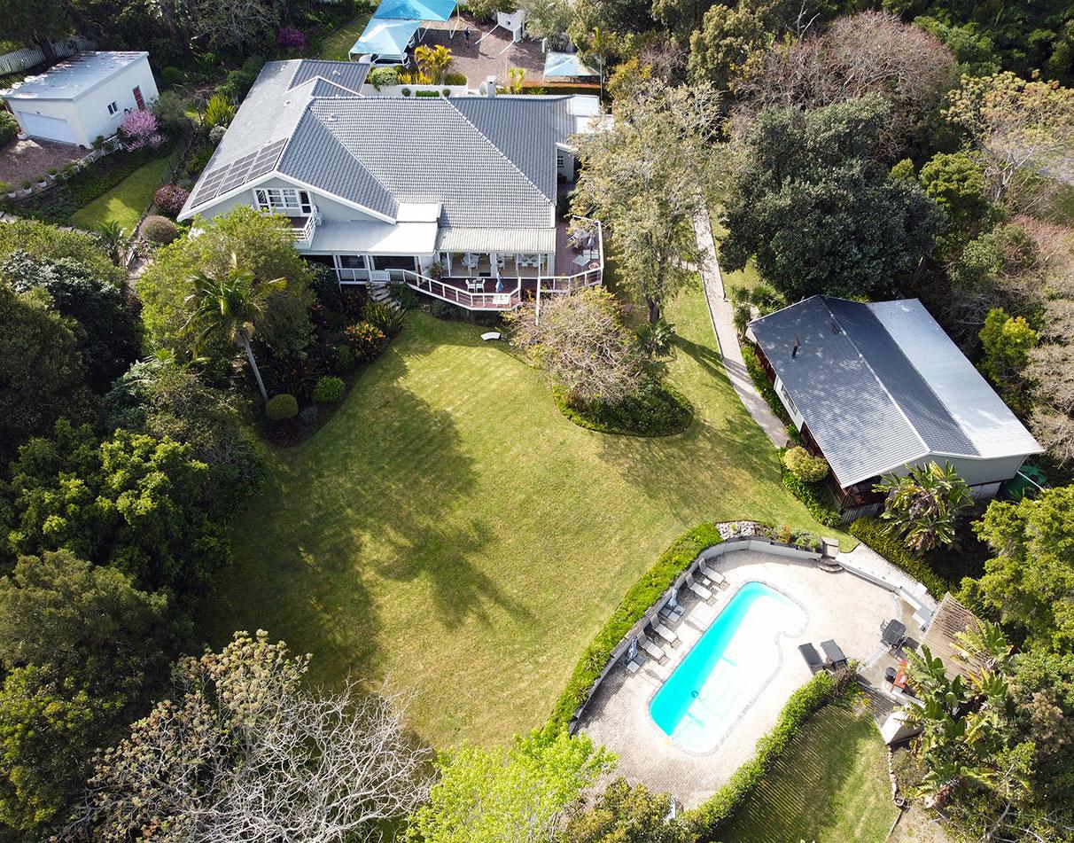 Aerial view of Stannards Guesthouse surrounded by lush gardens with a swimming pool and spacious lawn.