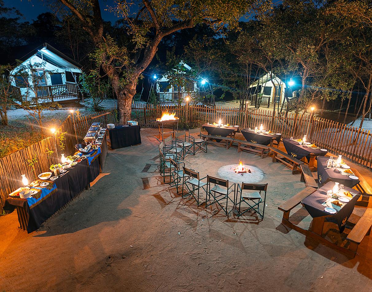 Outdoor boma dinner setup at night at Buffalo Rock Lodge, South Africa.