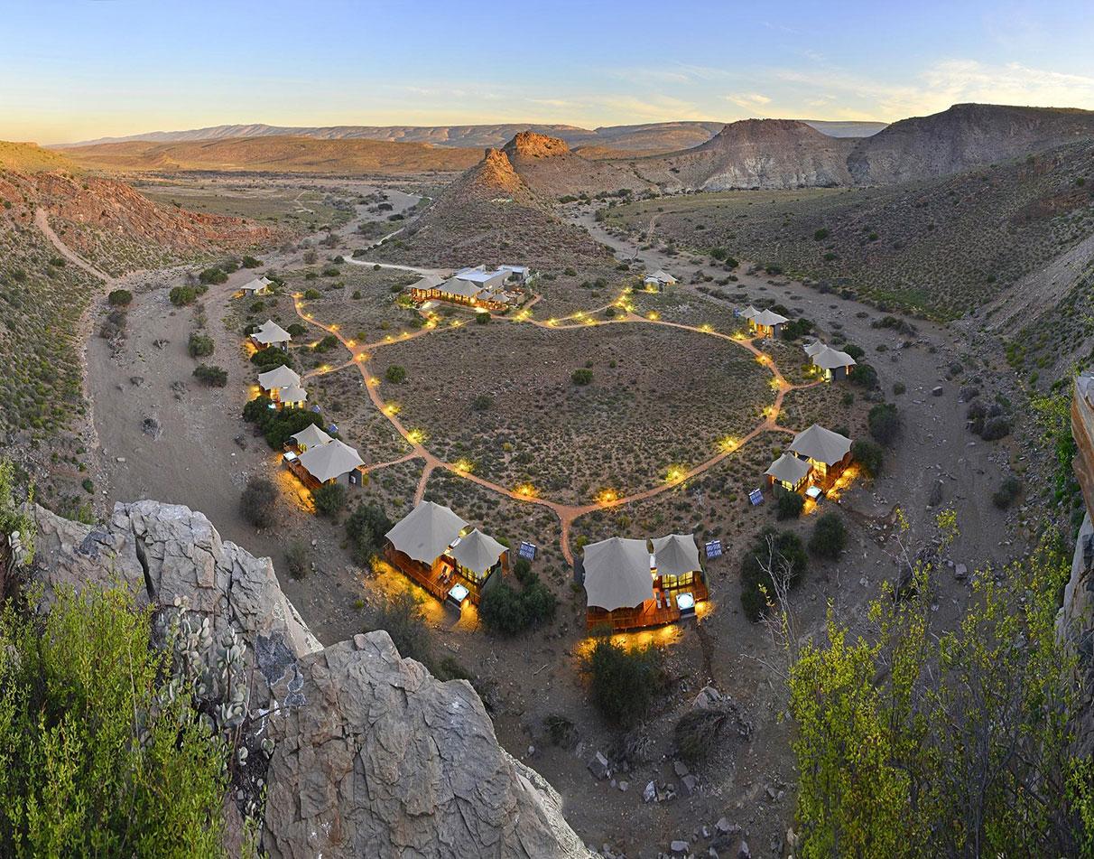 Aerial view of luxury tented suites nestled in a desert valley at Sanbona Wildlife Reserve.