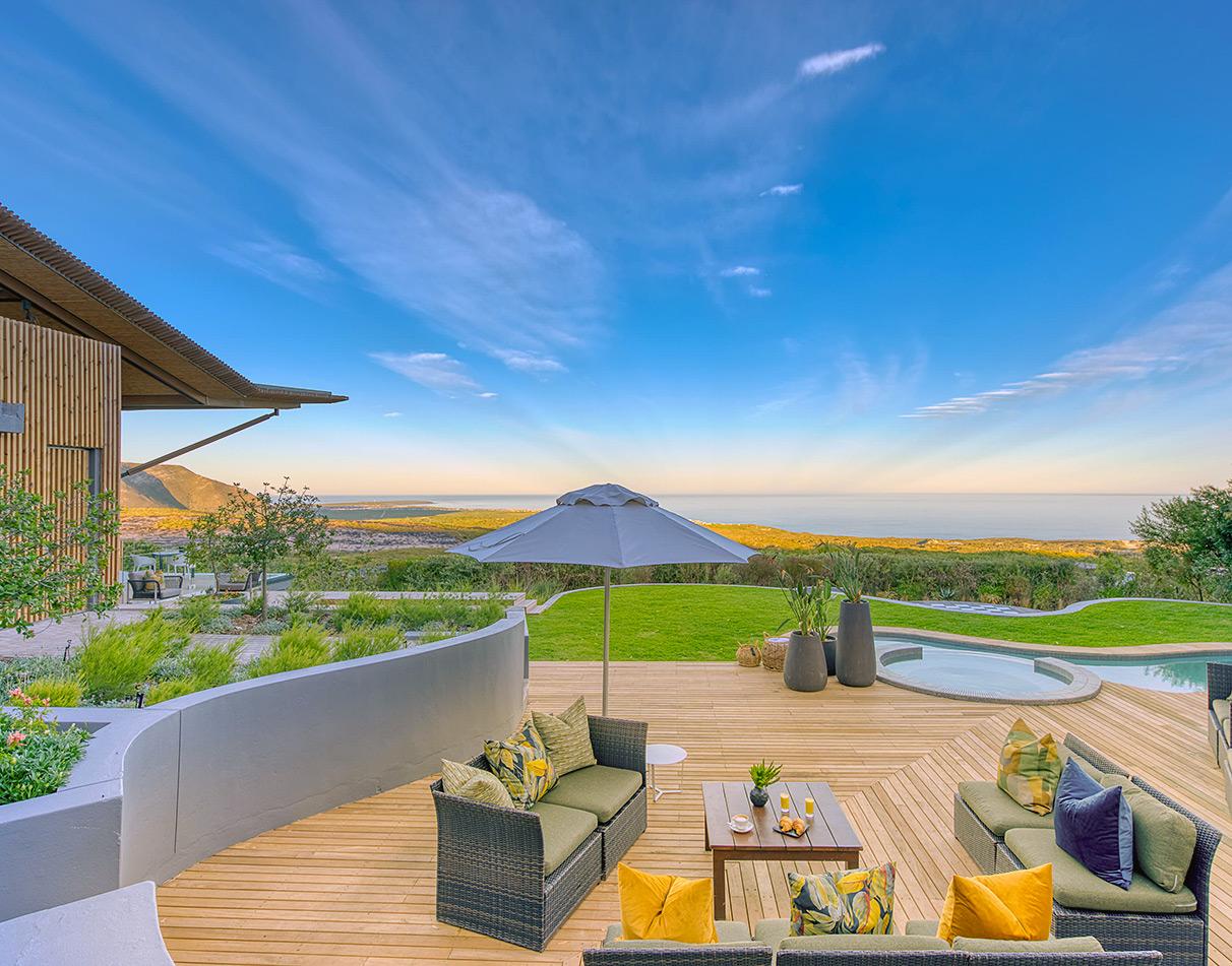 Grootbos Garden Lodge wooden deck with pool and panoramic views over the fynbos and Walker Bay coastline.