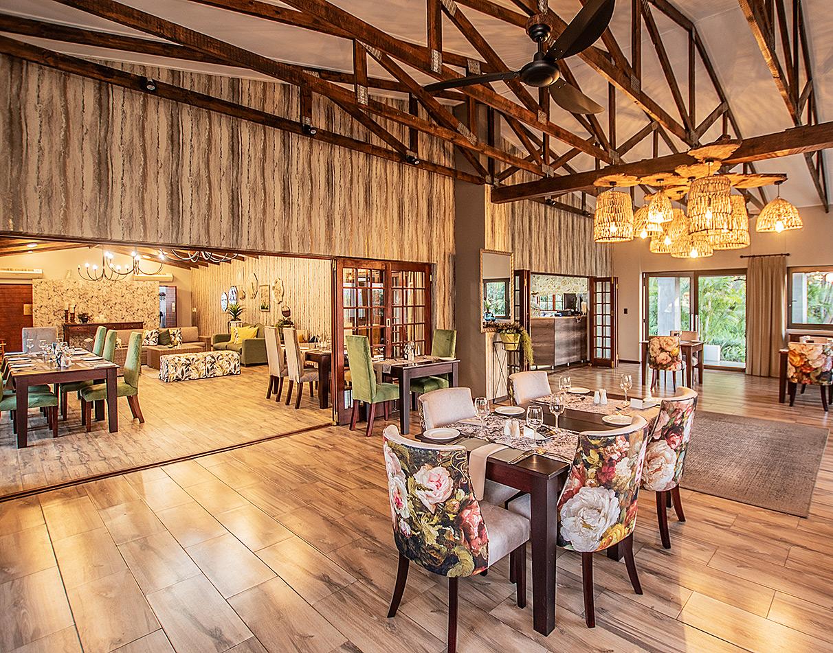Elegant dining room with floral chairs and wooden beam ceiling at Nut Grove Manor.
