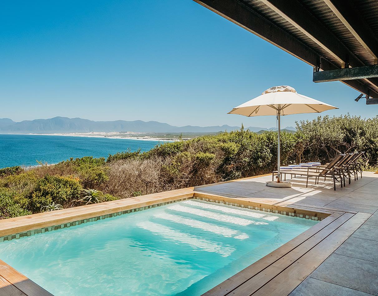 Pool deck with sun loungers and panoramic ocean views at Cliff Lodge, Hermanus.