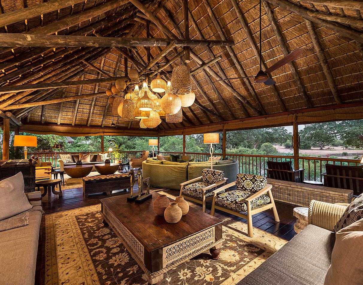 Sabi Sabi Bush Lodge open-air lounge with thatched roof, woven pendant lights, African décor and bush views.
