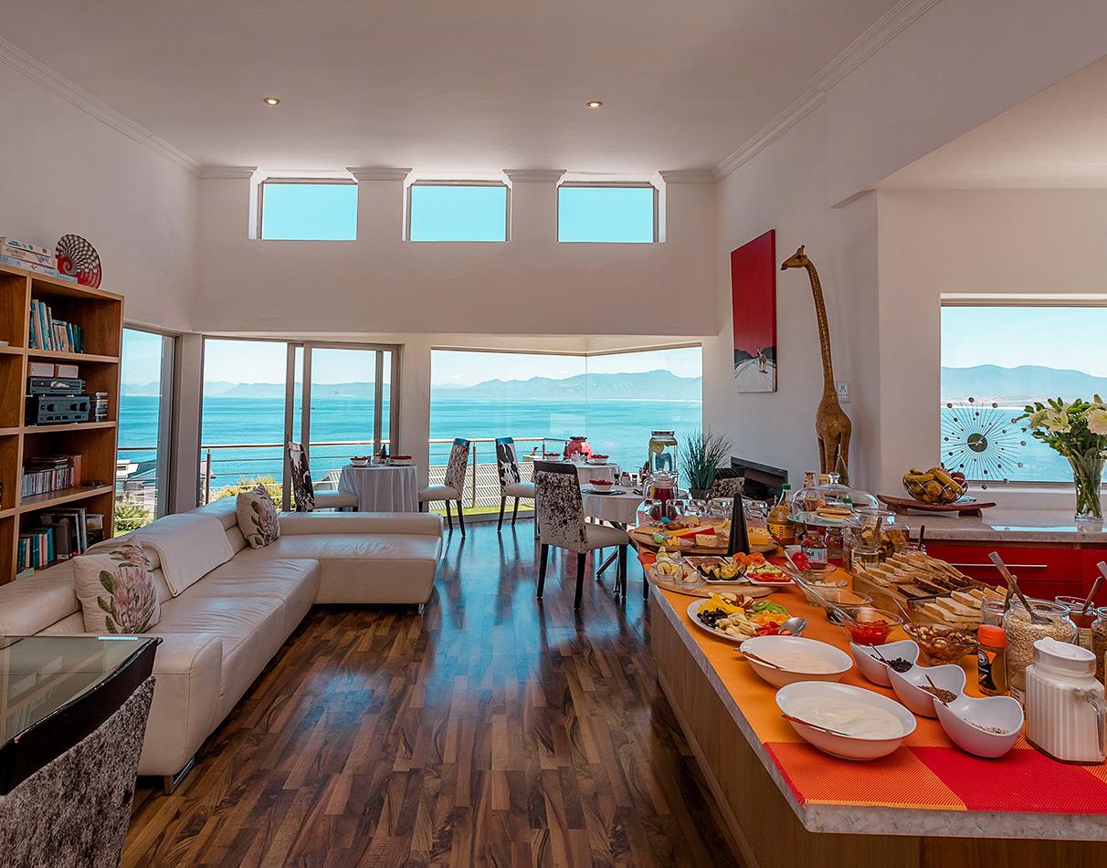 Breakfast spread in the open-plan dining area at Sea Star Lodge, with panoramic ocean views, Hermanus.