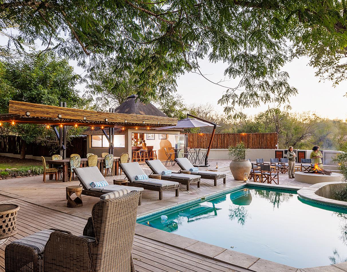 Pool deck with loungers and fireplace at Simbavati Amani, South Africa.