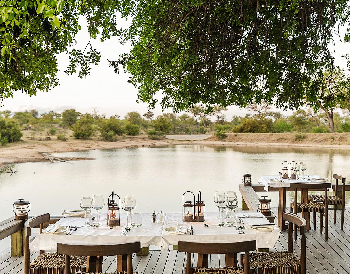 Dining tables overlooking a waterhole at Simbavati, South Africa.