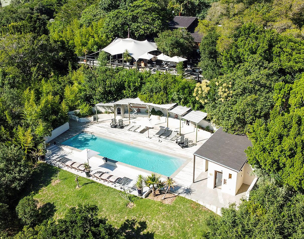 Aerial view of Hog Hollow Country Lodge pool deck nestled inbetween trees.