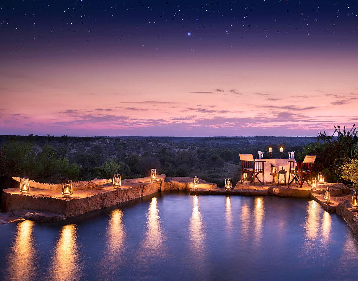 Romantic dinner setting at Makumu Lodge overlooking the Kruger National Park, by the pool.