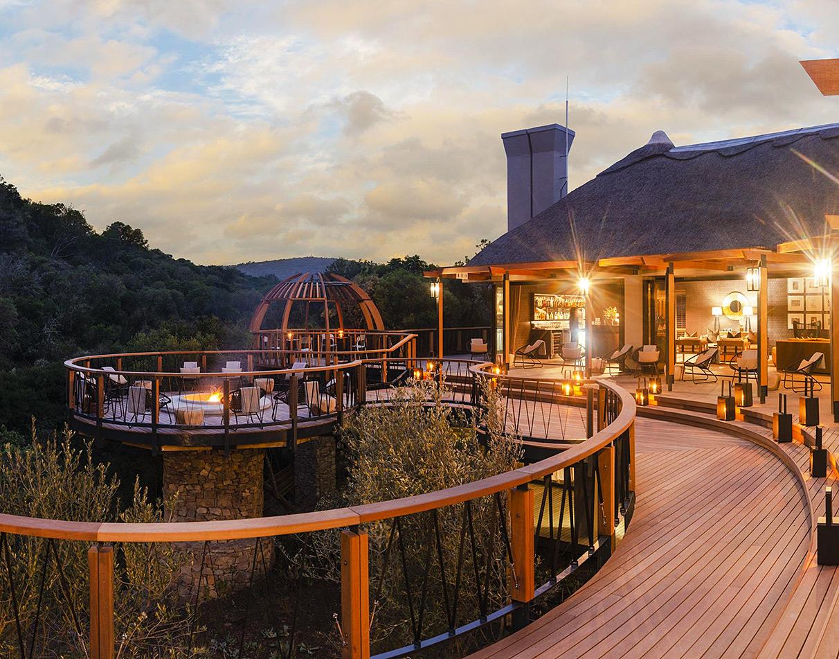 Eagles Crag at Shamwari veranda terrace lit up in the evening with warm ambient lighting.
