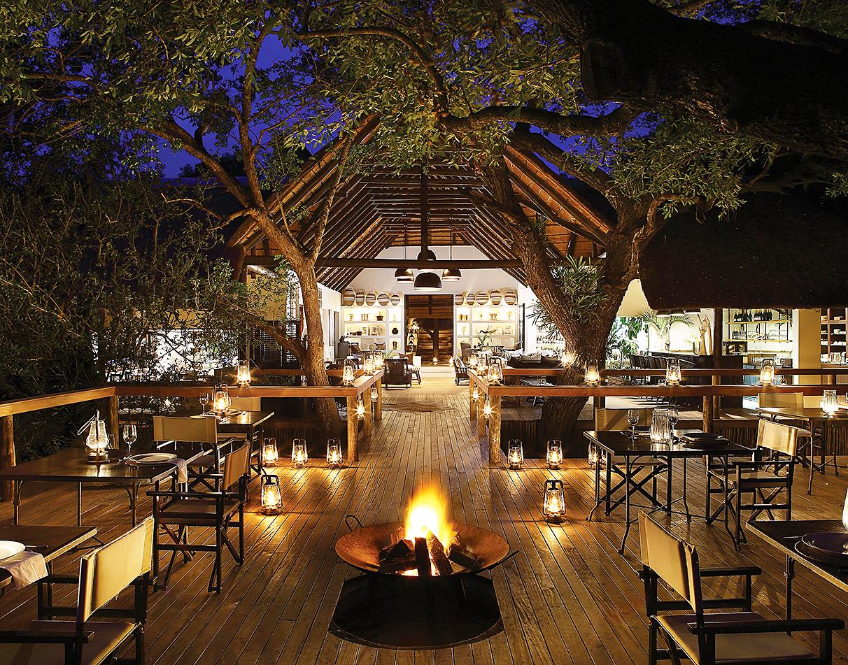 Londolozi tree camp exterior dining area by candlelight.
