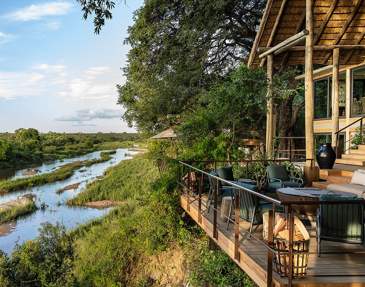 Singita Ebony Lodge deck overlooking the river at golden hour.