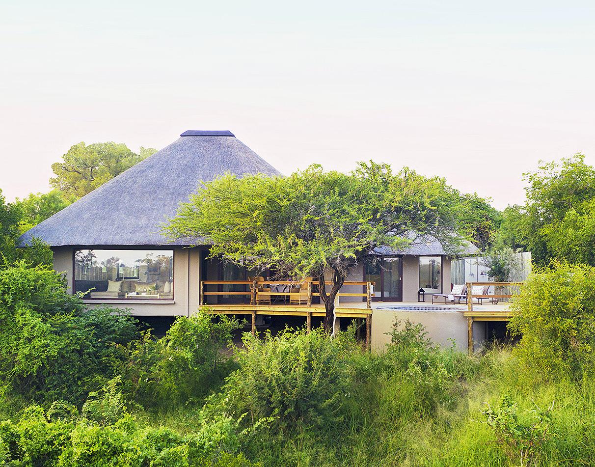 Londolozi Pioneer Camp lodge nestled in the bush with thatched roof and wooden deck.