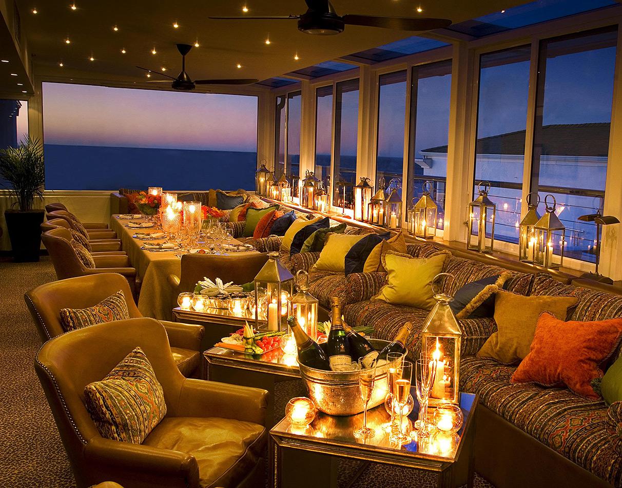 Candlelit dinner setting at Twelve Apostles Hotel with ocean views at dusk and champagne service.