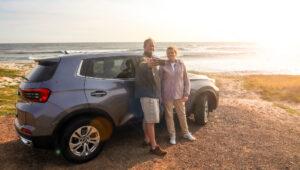 A couple stopping to take photos of the ocean view on a self-drive trip along the coast, South Africa.