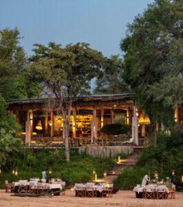 Thornybush Saseka tented lodge dining area illuminated at dusk.