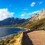 Coastal road winding towards Hermanus with mountain and sea views.