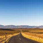Long straight road through the golden Klein Karoo towards Oudtshoorn.