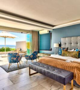 Ocean View House stylish double room with blue accents and ocean-facing windows.
