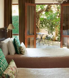 Bayflowers Guesthouse interior bedroom with chandelier and warm earthy tones.