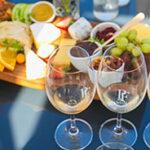 Two wine glasses, cheeses and grapes at a winetasting in Stellenbosch.