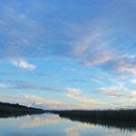 The St Lucia Estuary at sunset with clouds in the sky.