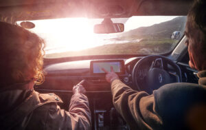 A couple navigating with a tablet on a self-drive safari along the South African coast.