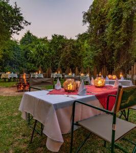Gecko Lodge outdoor dining setting with candlelit tables under the trees.