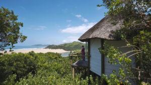 Woman on balcony overlooking lush landscape during guided hikes in South Africa