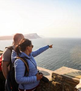 Hikers admiring the ocean view from a lookout point at Cape Point, South Africa.