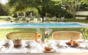 Outdoor breakfast table by pool, Elephant House, South Africa.