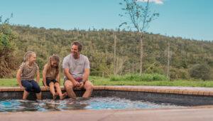 Father and children relaxing by the pool at Africamps, Addo.