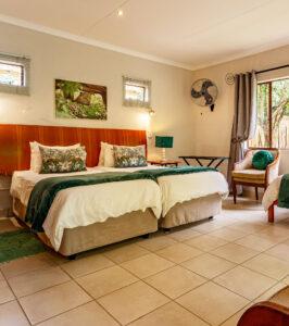 Gecko Lodge stylish twin room interior with green and red décor.