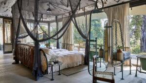 A tented lodge bedroom with four-poster bed at Saseka Tented Lodge.