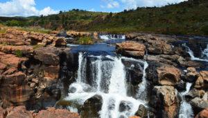 Cascading waterfall over rust-coloured rock terraces in the Blyde River Canyon, Panorama Route.