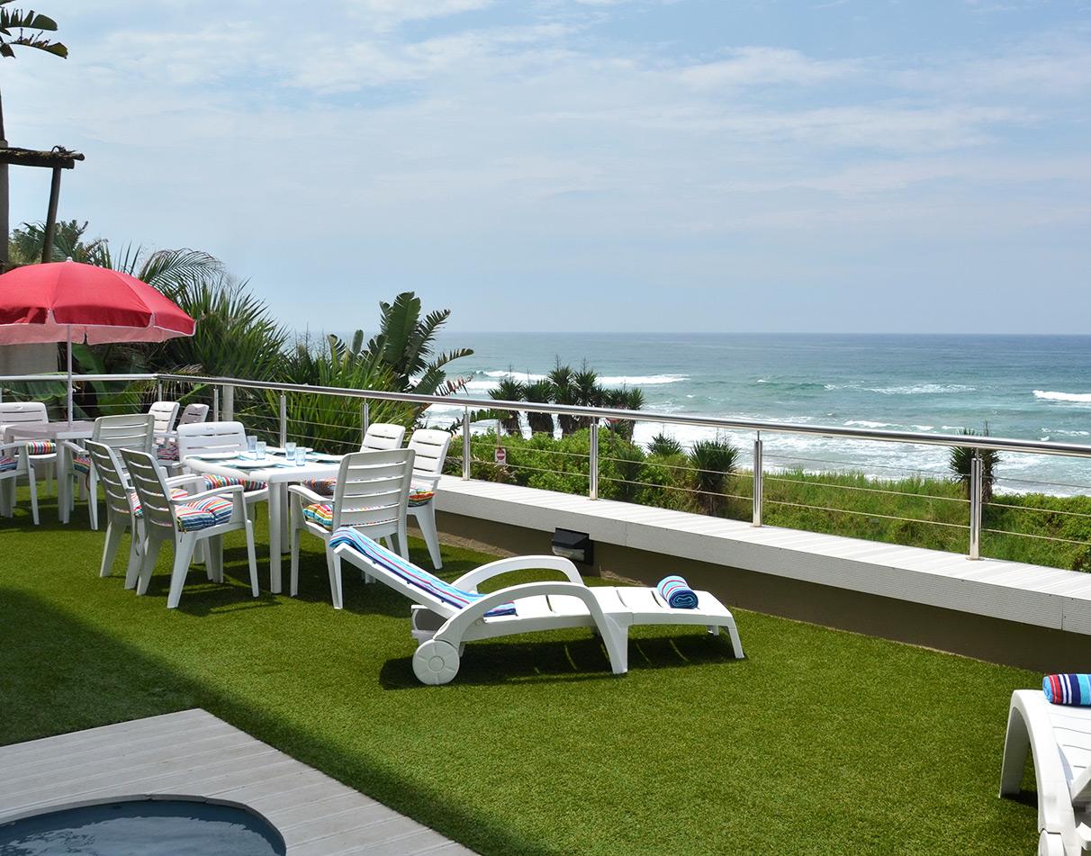 Views of sunbeds, the pool and the ocean at Greenfire Dolphin Lodge.