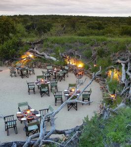 Outdoor bush dinner setup at Sabi Sabi Earth Lodge, South Africa.