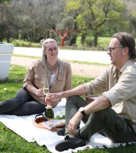 Guest couple having a glass of Champagne during their picnic in the Winelands near Cape Town.