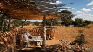 Open double room with shaded outdoor seating overlooking the bush at Tswalu Motse.