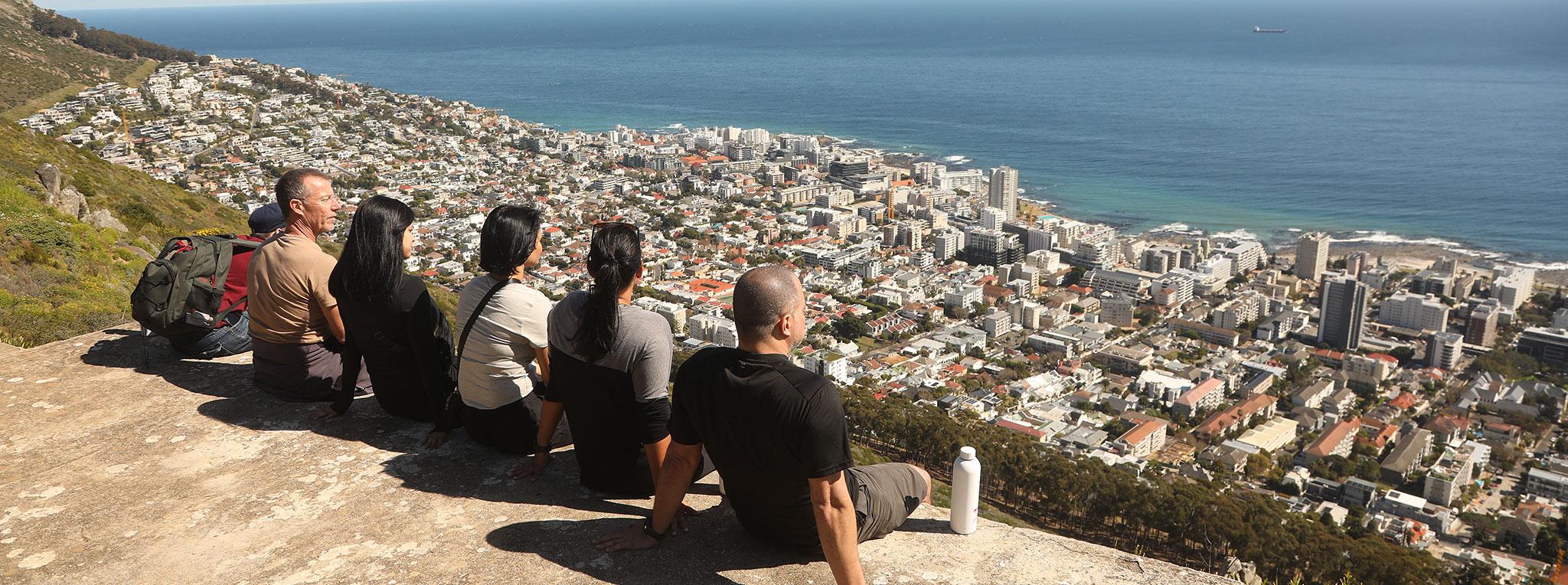 Small group hiking and admiring views over Cape Town from the mountain, South Africa.