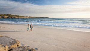 Couple walking along a white sandy beach near Grootbos Garden Lodge, Gansbaai.