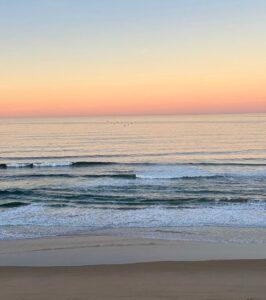 Beautiful golden sunset on calm ocean viewed from the beach in Wilderness.