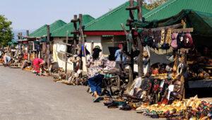 Row of roadside craft market stalls with local vendors selling carvings, crafts and souvenirs along the Panorama Route.