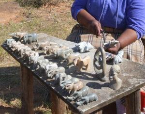 Local woman sculpting rocks into wild animals.
