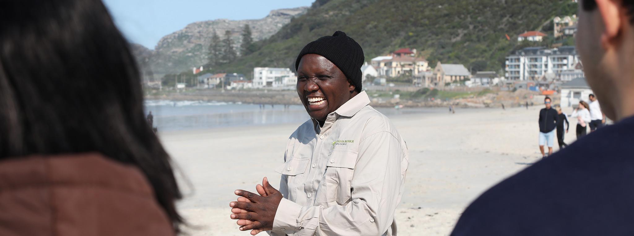 SouthAfrica Experience guide laughs as he talks to his guests at Muizenberg beach.