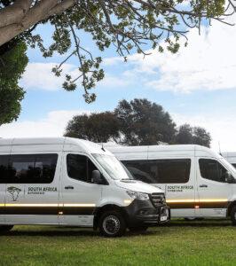 South Africa Experience tour vehicles parked on grass.