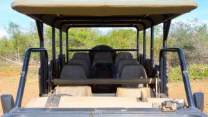 An open safari vehicle parked in the bush