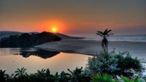 A vivid orange sunset over the river at Mbotyi River Lodge., Wild Coast South Africa.