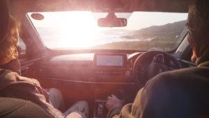 A couple sitting in a rental car using a GPS to gt around South Africa.